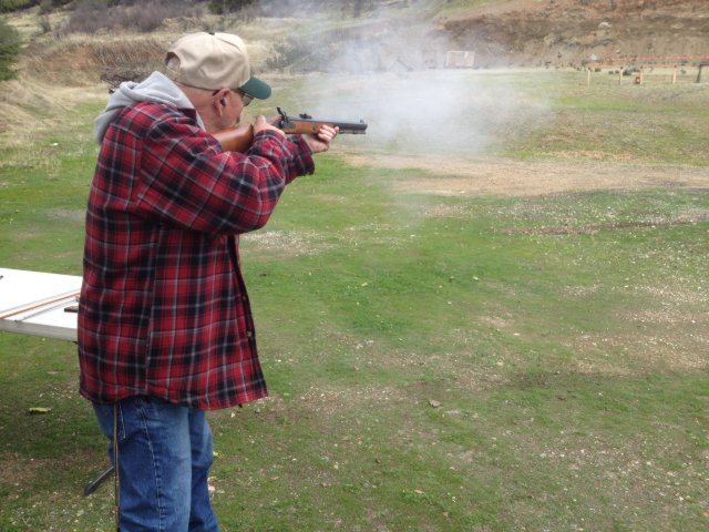 Member firing a shotgun on the trap field
